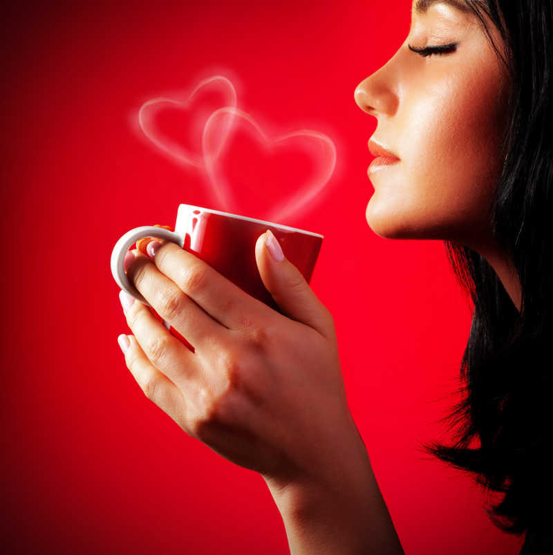 红色背景中喝咖啡的年轻女性