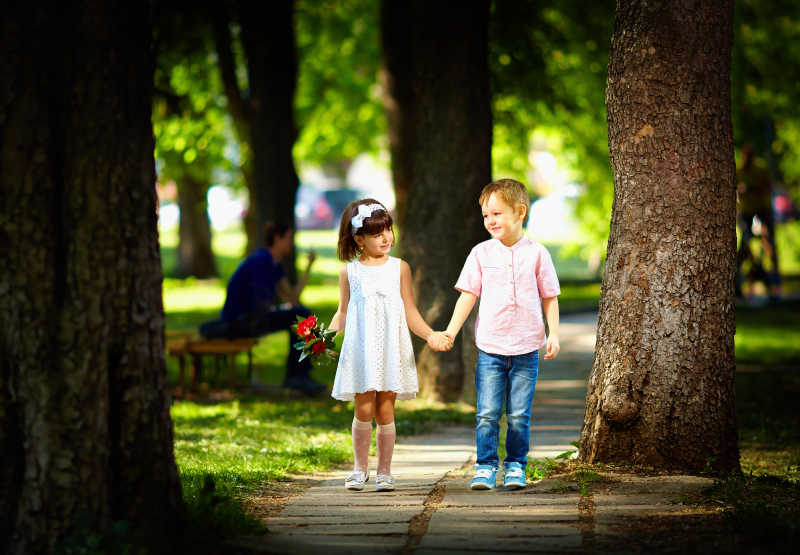 可爱的孩子在夏日公园散步