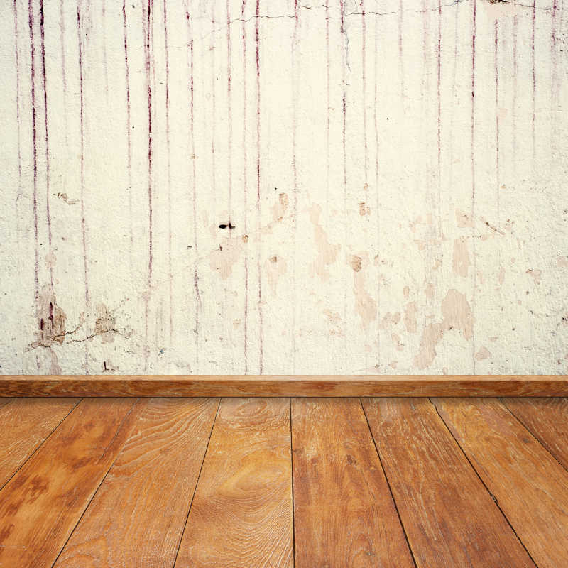 木质地板和破旧的混泥土墙相连接背景