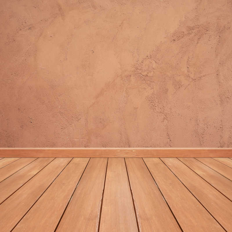 木地板和红铜色混泥土墙壁相连接背景