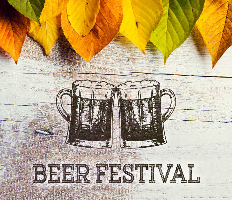 木制背景和彩色叶子点缀下的啤酒节标志