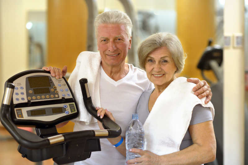健身房内积极锻炼的老年夫妇