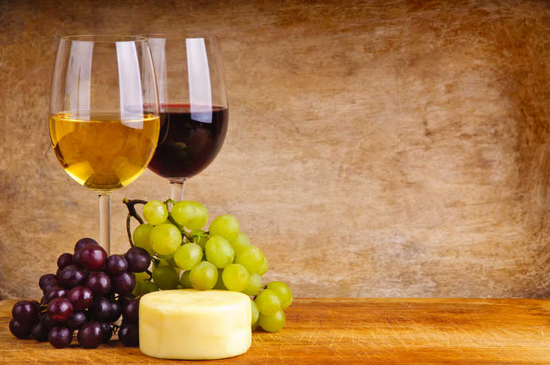 木桌上的葡萄与葡萄酒和奶酪