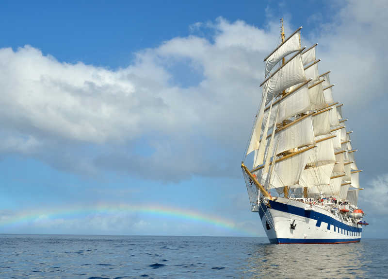 彩虹背景下的白色帆船