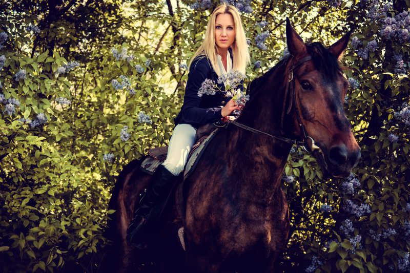 金发女子骑马坐在马背上
