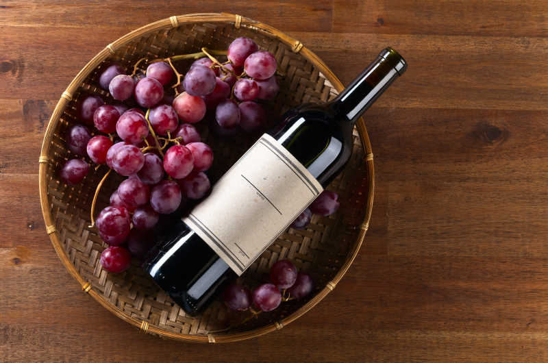 放扎木桌上的新鲜葡萄和红酒
