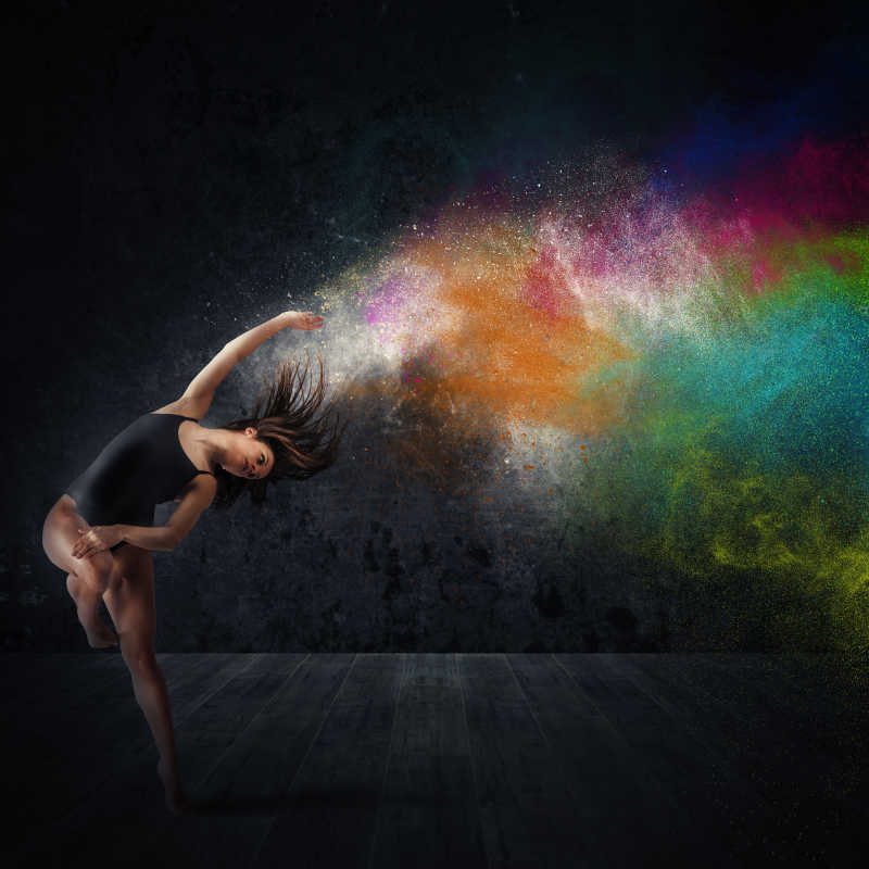 挥出彩色颜料的创意女孩的舞蹈