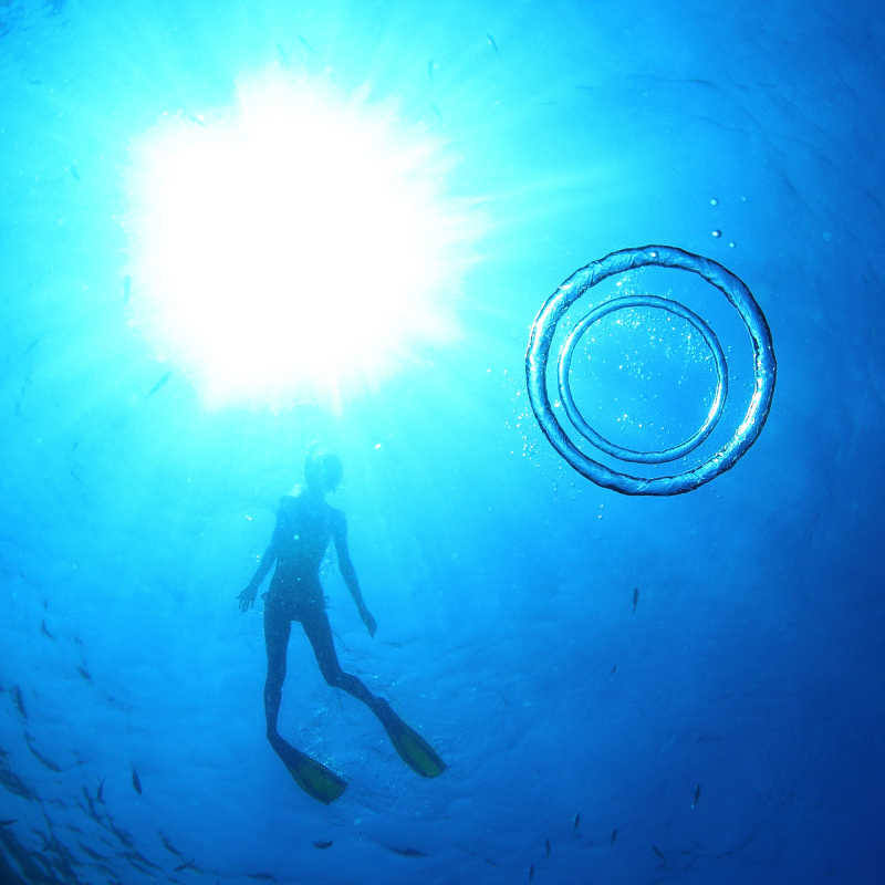 神奇美丽的海底世界的女性剪影与两个圆形气泡的水下拍摄