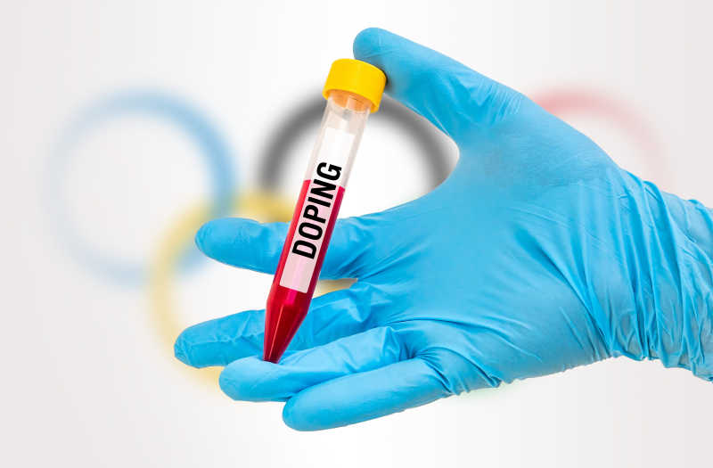 奥运五环背景前科学家手持血液兴奋剂检查试管