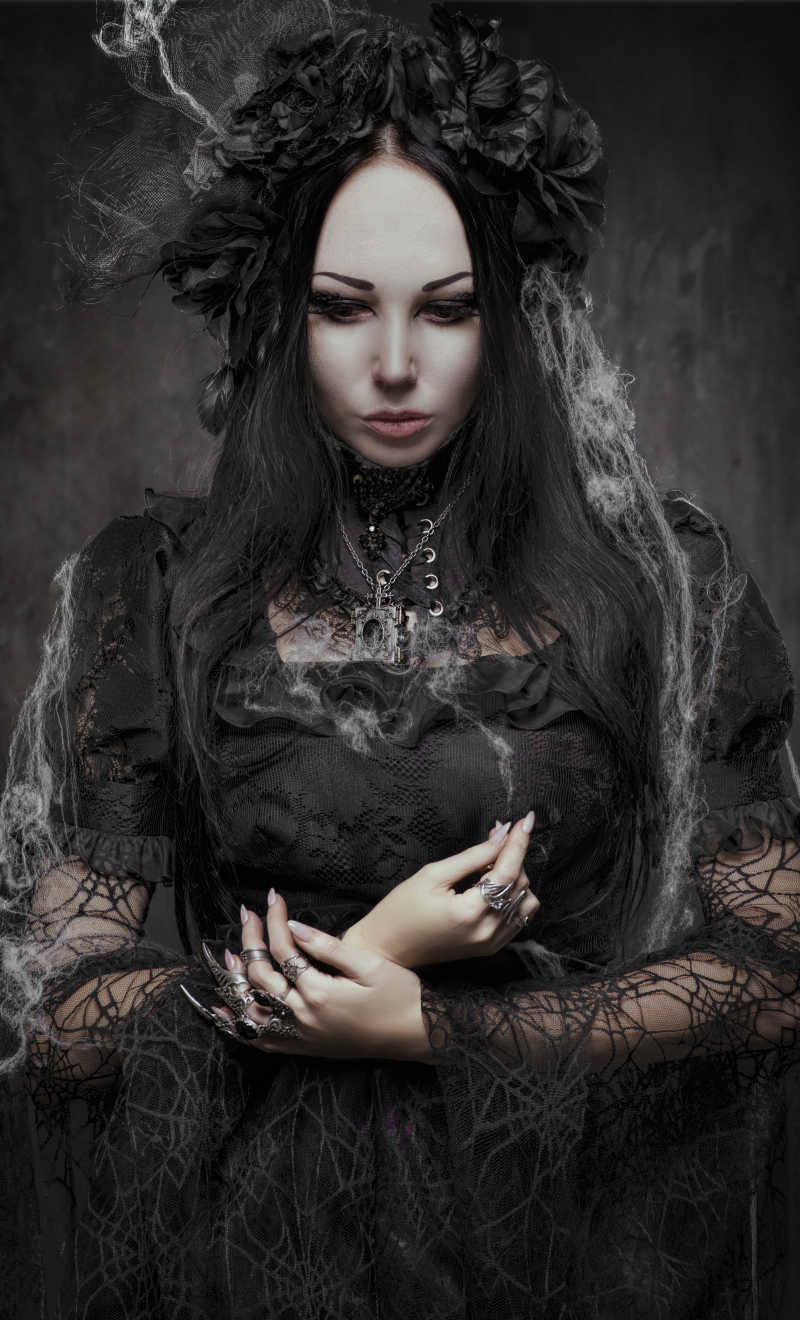 美丽的哥特式女人穿着连衣裙在暗黑中