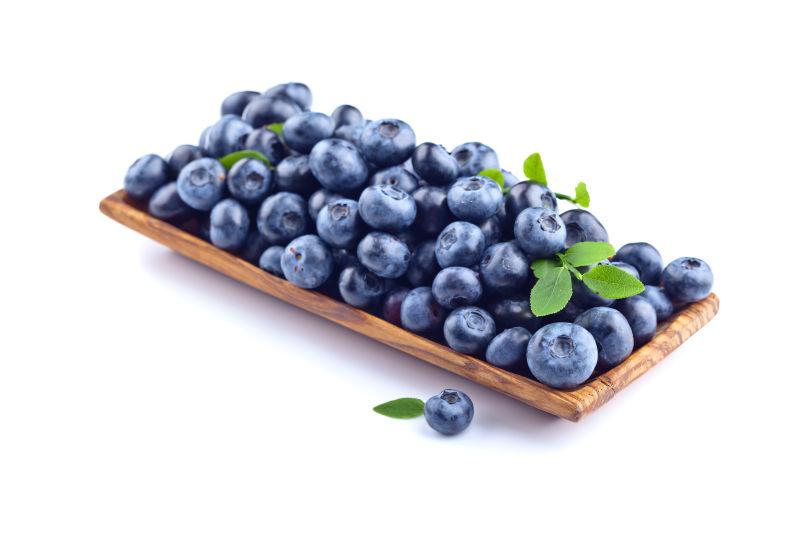 白色背景下木盘中的蓝莓