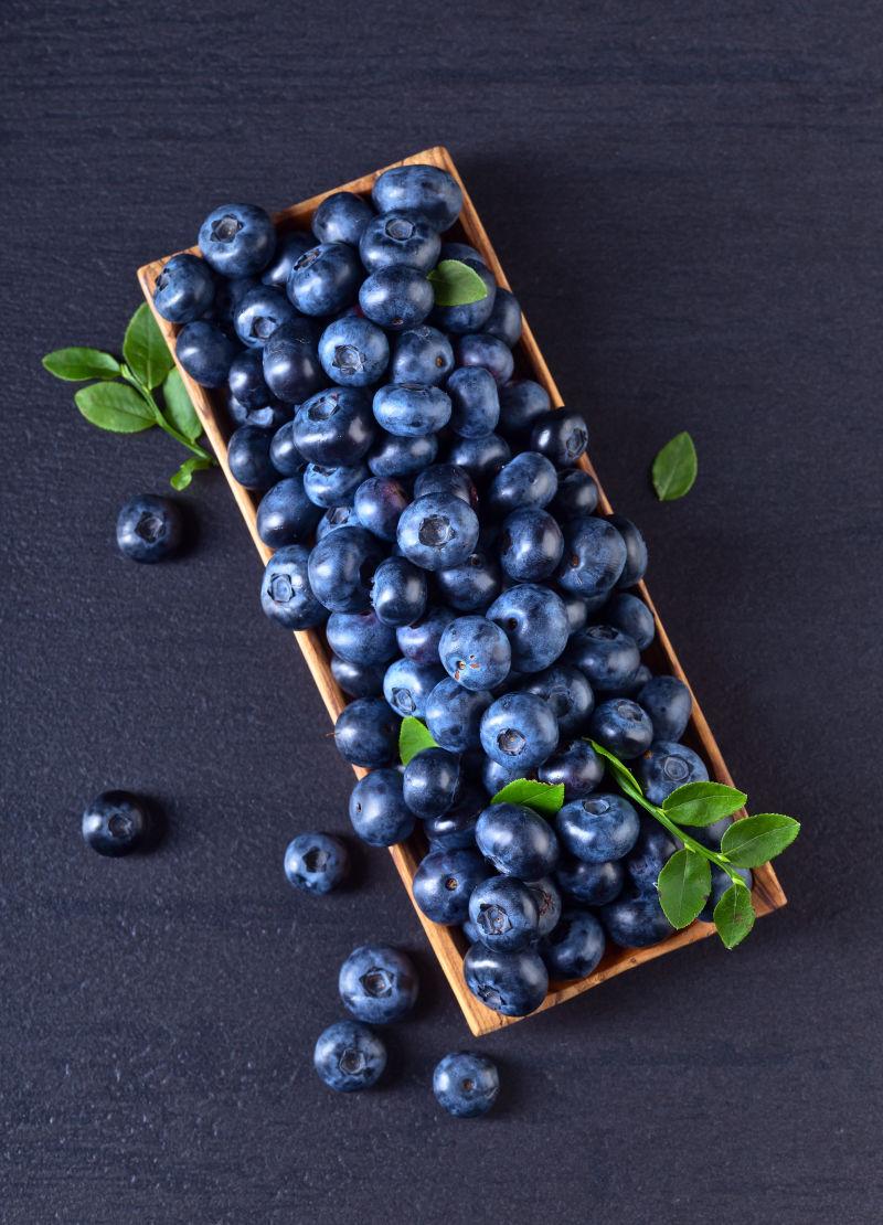 木盘中散乱堆放的蓝莓