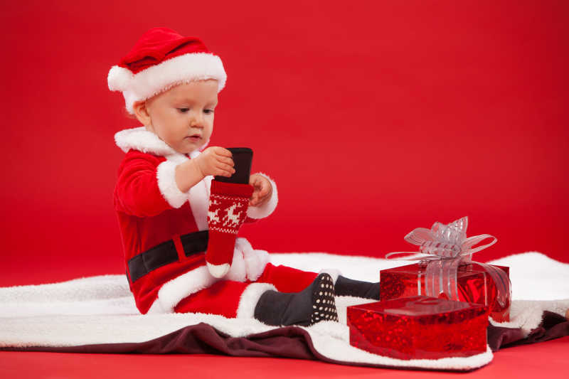 圣诞装扮的孩子带着礼物和电话