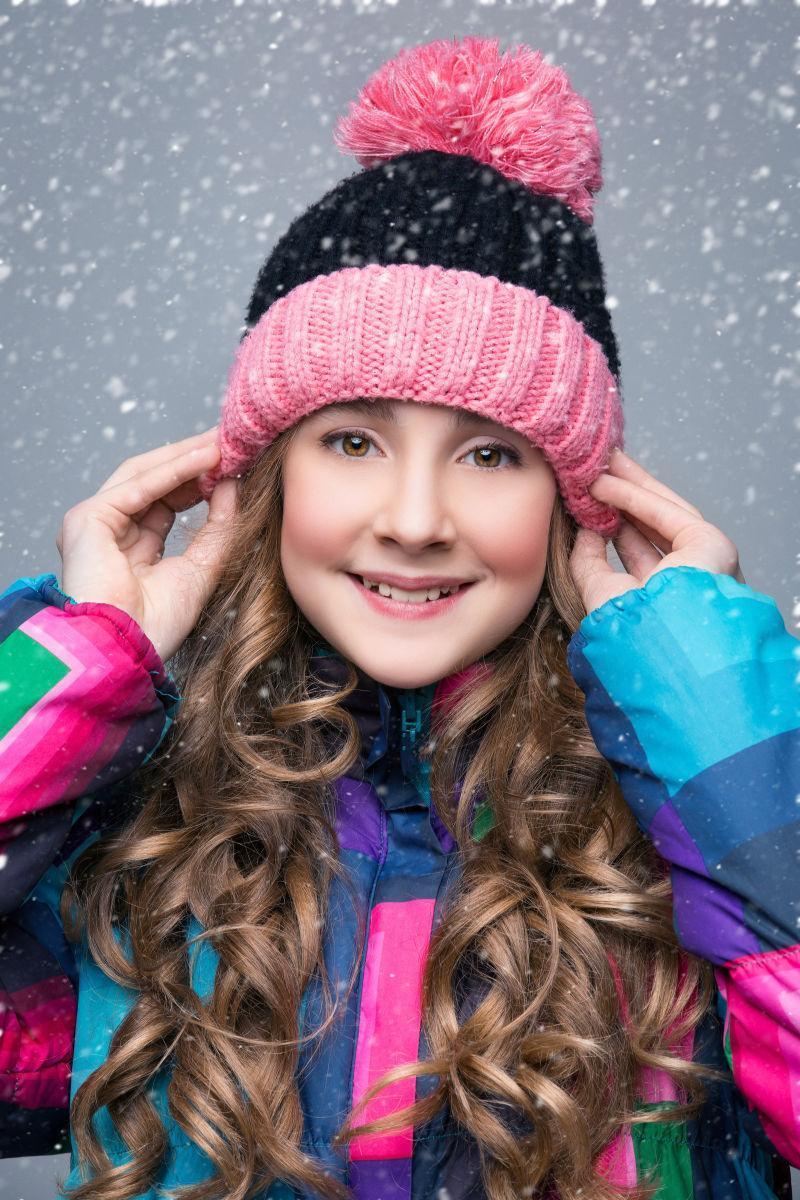 雪中戴着帽子的小女孩