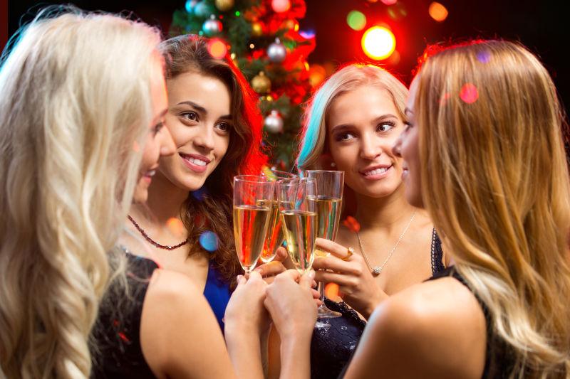 快乐的年轻女人用香槟酒庆祝圣诞节