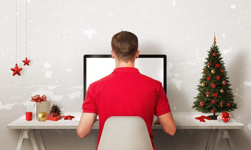圣诞节的男人使用电脑努力工作