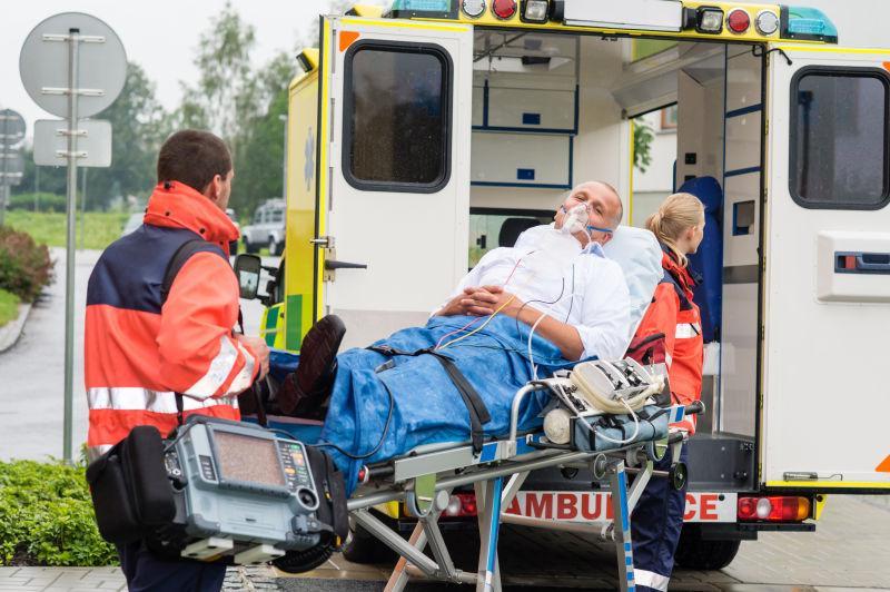 医护人员把氧气面罩男患者用担架抬上救护车