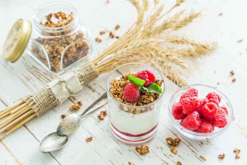 白色桌上的牛奶燕麦片和红色蔓越莓浆果的早餐