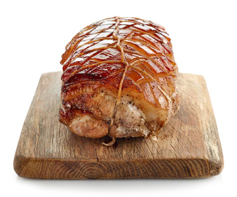 白色背景砧板上的美味烤猪肉
