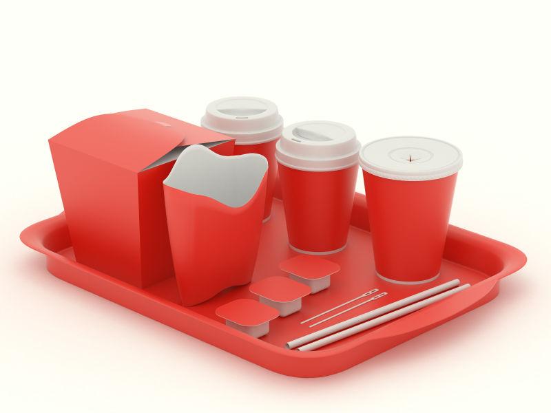 单色背景上放在托盘里的红色快餐餐具模型