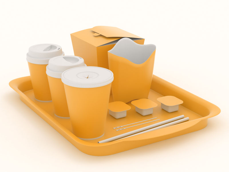 单色背景上放在托盘里的橙色快餐餐具模型