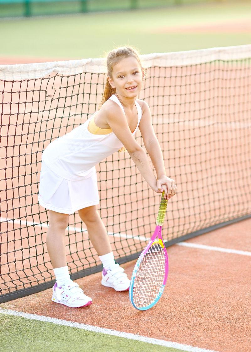 网球场上打网球的小女孩