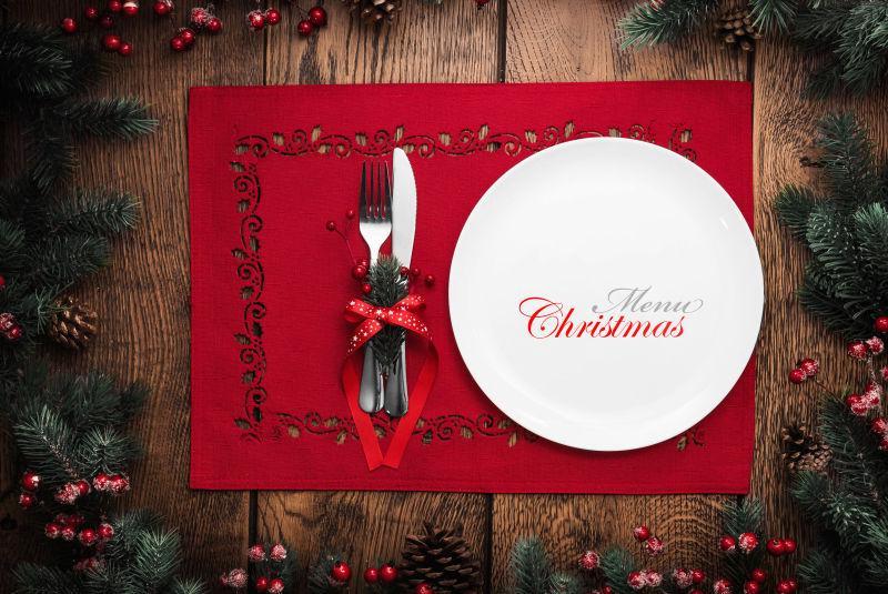 红色圣诞菜单上的带着圣诞饰品的厨具