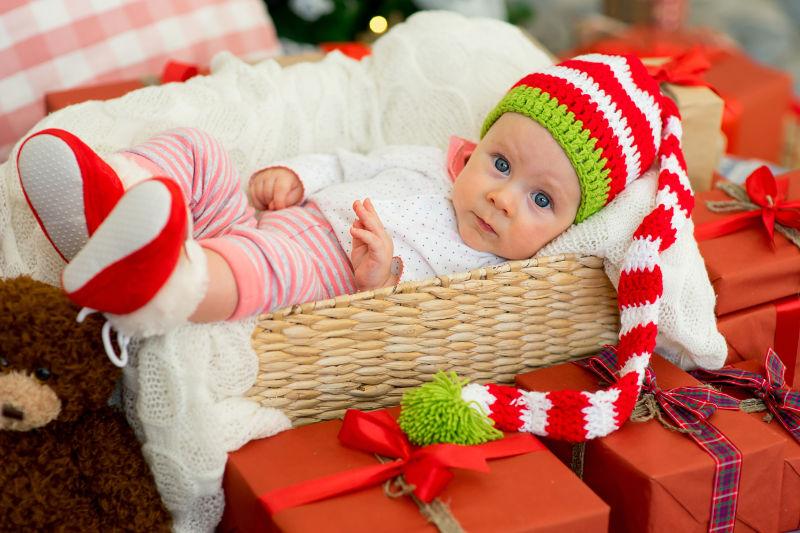 在婴儿筐里的圣诞婴儿与他的礼物