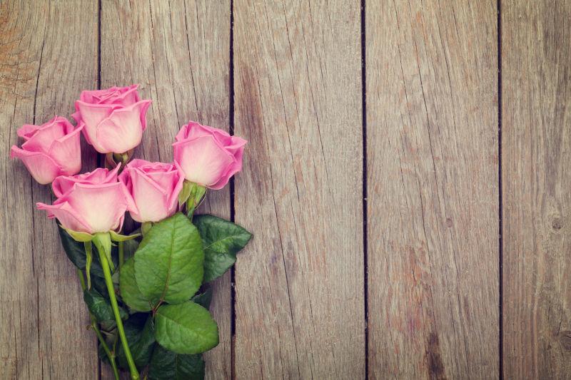 木桌上的粉红玫瑰的花束