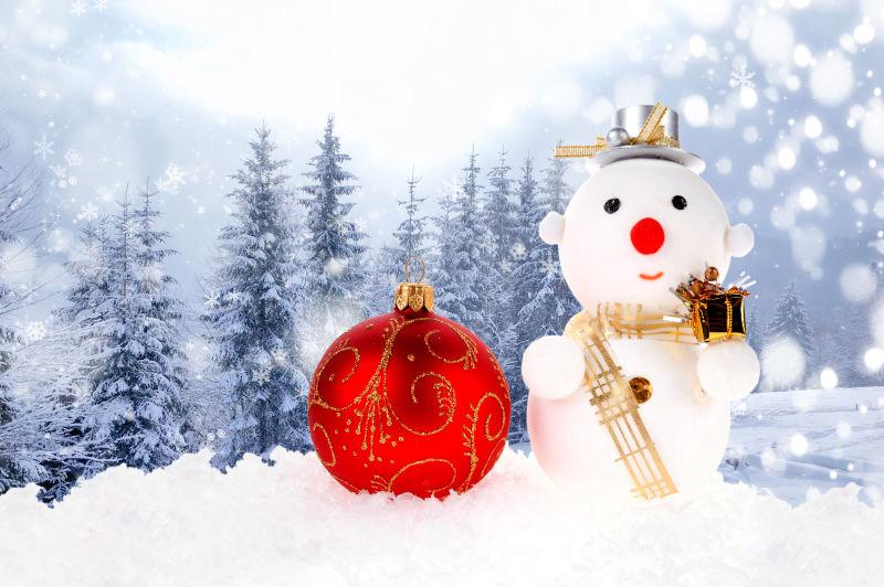 户外雪地上的可爱雪人和红色圣诞铃铛