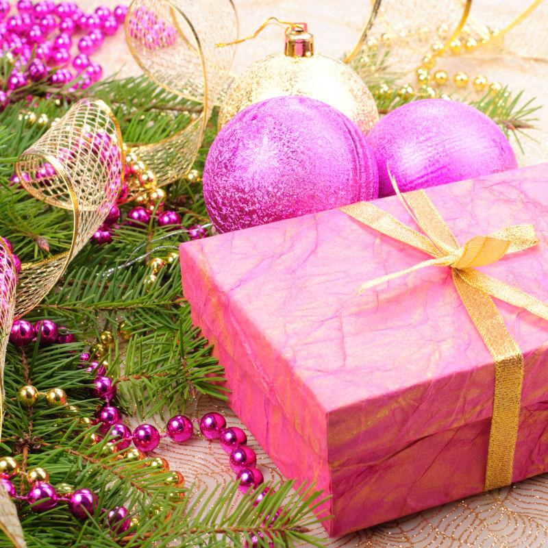 松树枝上的圣诞节粉色礼品盒和粉色装饰品