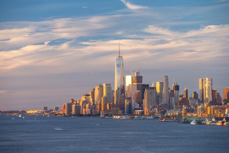 蓝天白云下有日落的纽约市曼哈顿市建筑天际线