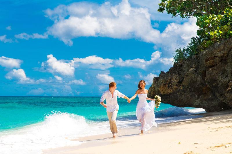 在海滩奔跑的新郎新娘