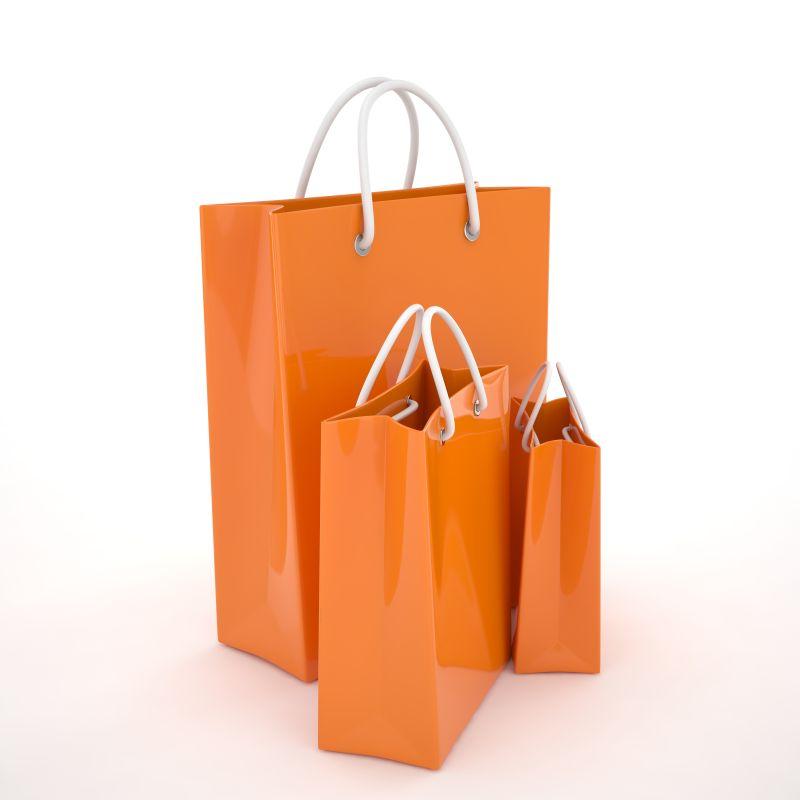 白色背景下的不同大小的橙色纸质购物袋