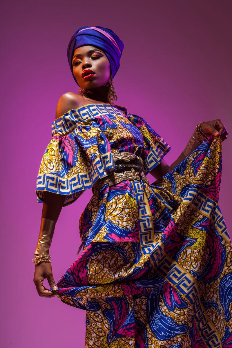 紫色背景下穿民族服装跳舞的非洲美女