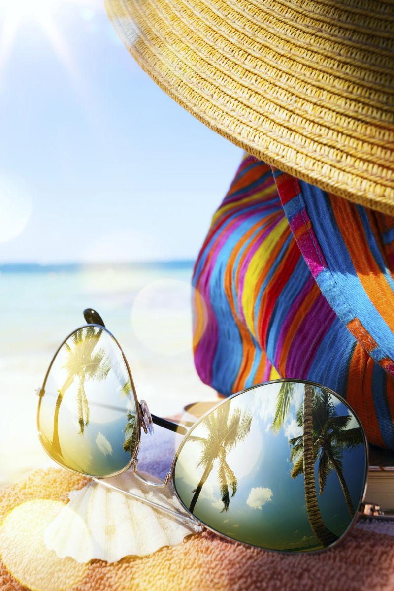 热带海滩上的草帽包和太阳镜