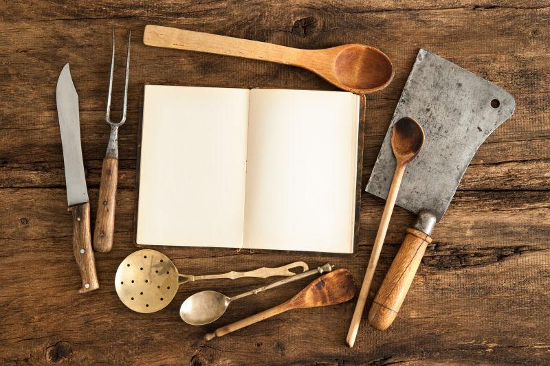 木桌上的空白菜谱和老式厨房用具