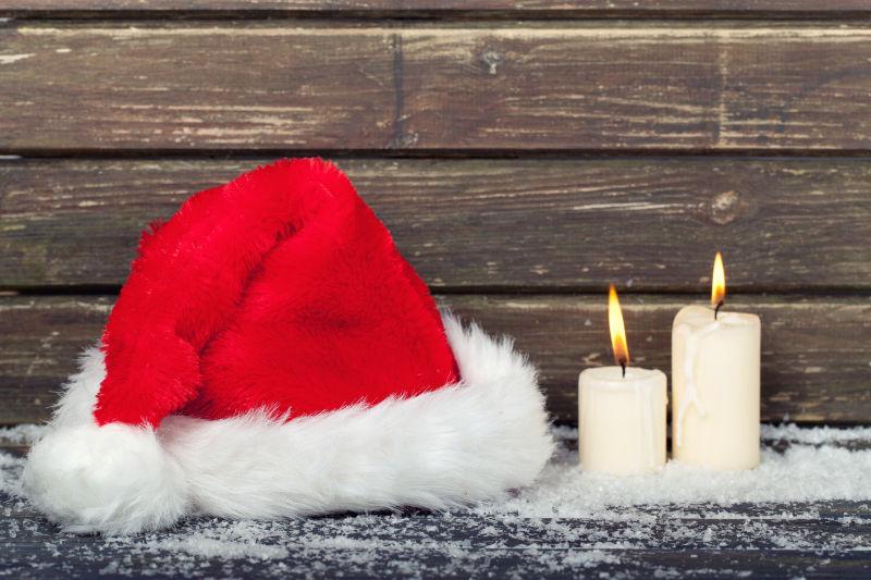 带红色圣诞老人帽和蜡烛的圣诞木板