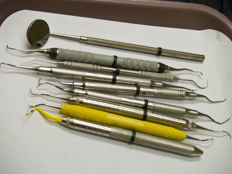 九个牙科工具放置在牙医准备好的托盘上