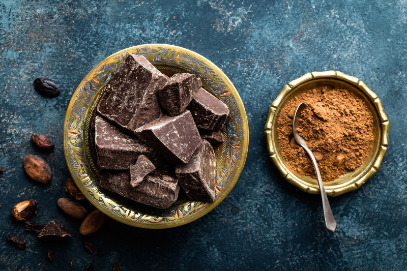 碗里的黑巧克力碎块和可可豆俯视图