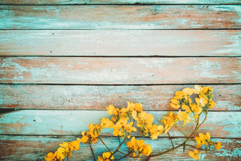 黄色花朵上陈设木板背景上