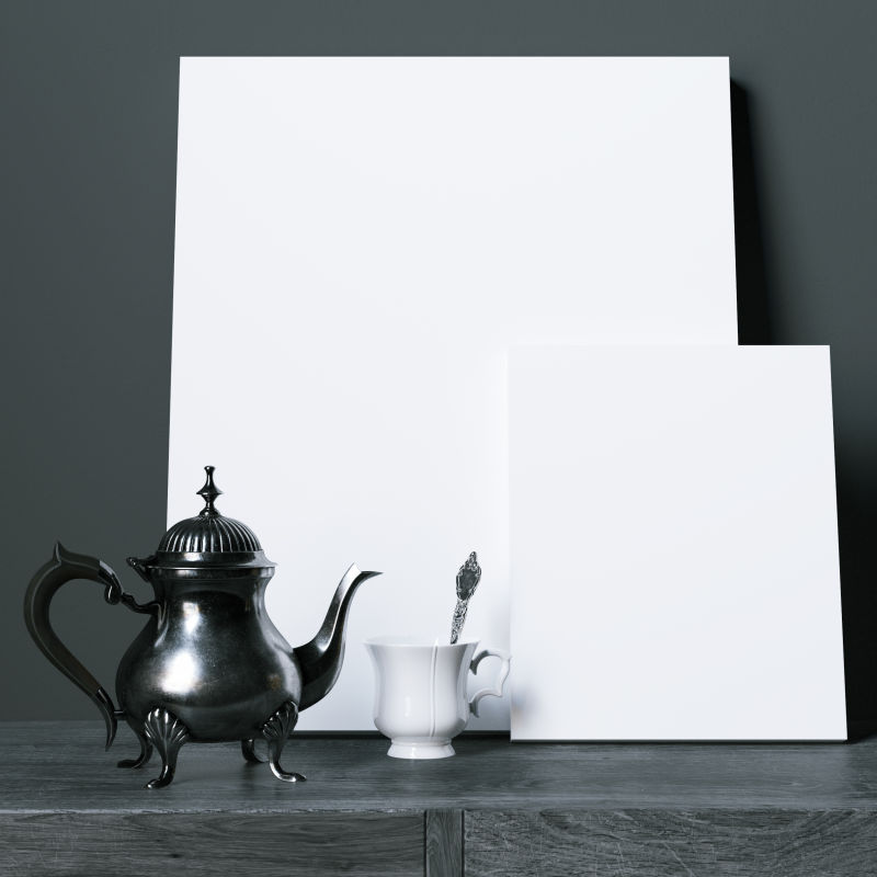在黑木桌上放着空白海报与咖啡壶