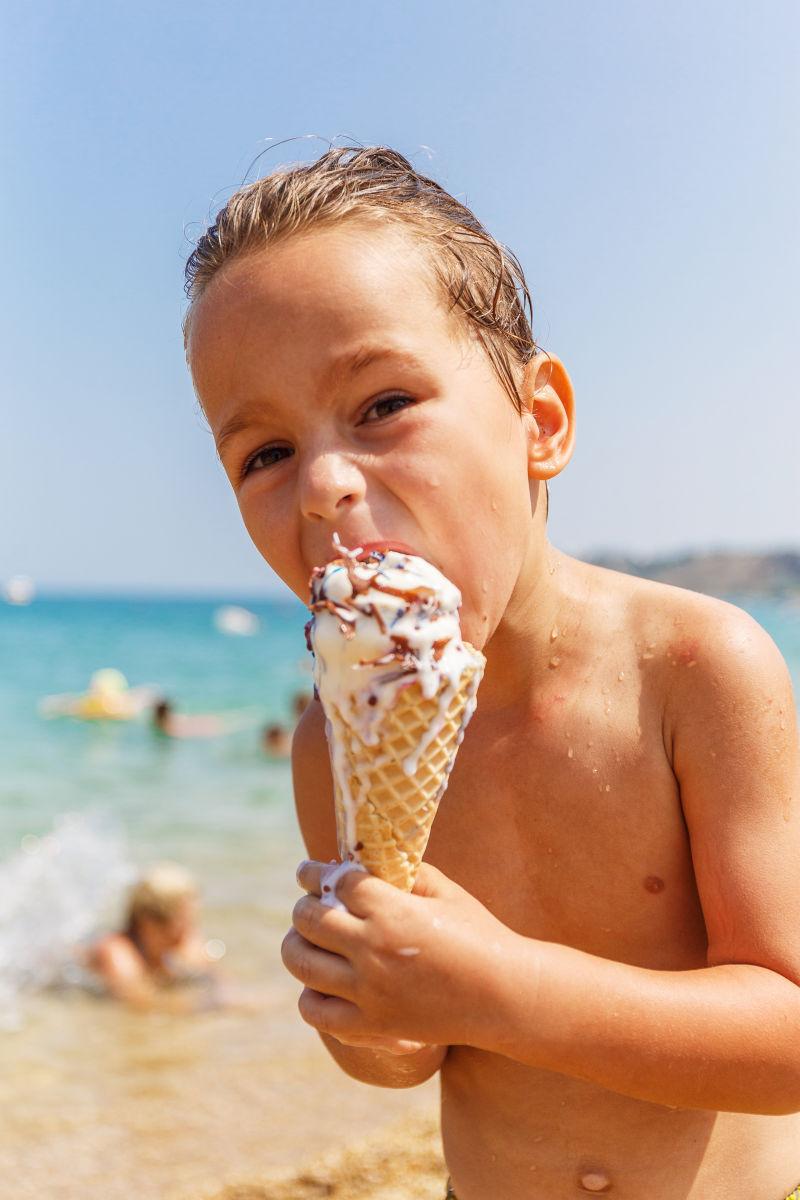 沙滩上正在吃冰淇淋的男孩
