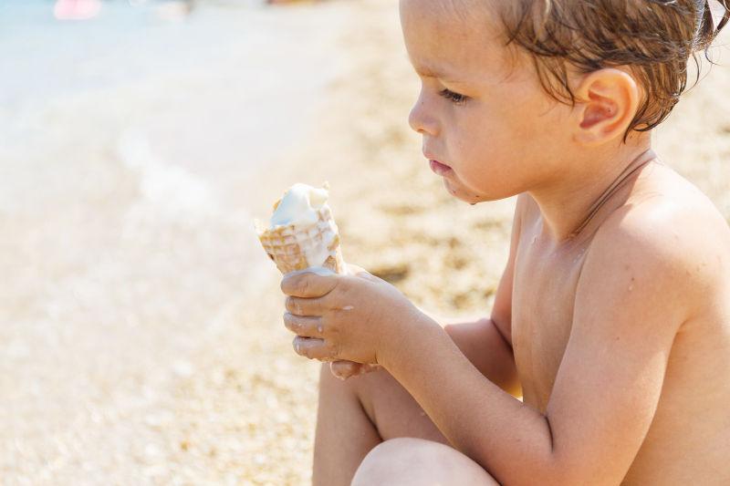 沙滩上吃冰淇淋的男孩