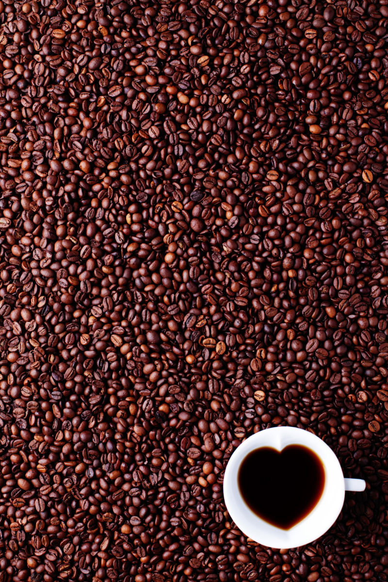 咖啡豆背景和一杯爱心咖啡