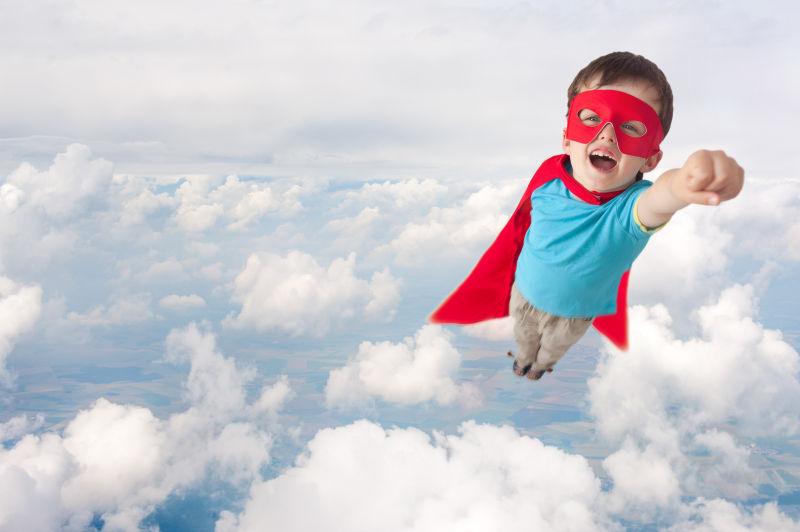 超级英雄男孩在云层上空飞行