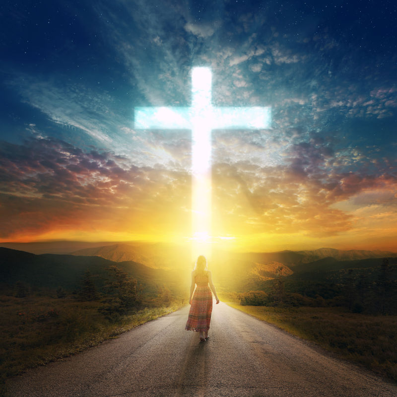 一个女人沿着一条路走向十字架