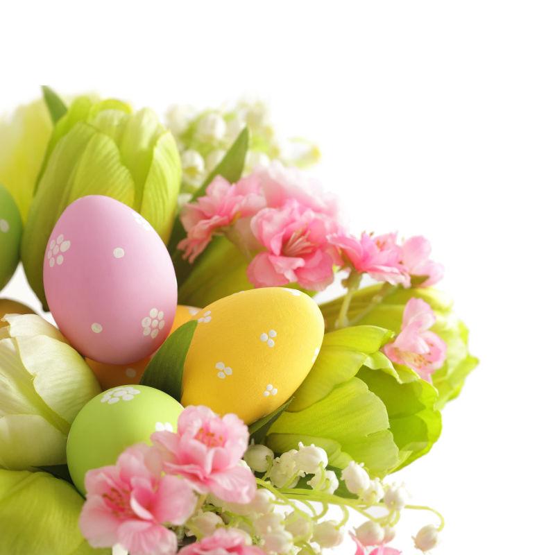 白色背景下复活节彩蛋和郁金香组成的花束