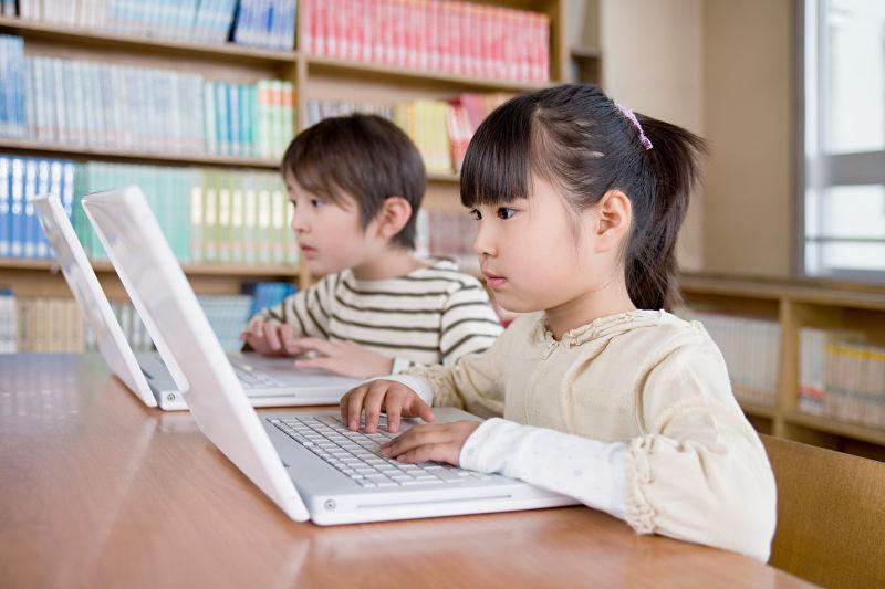 男孩女孩在使用笔记本电脑