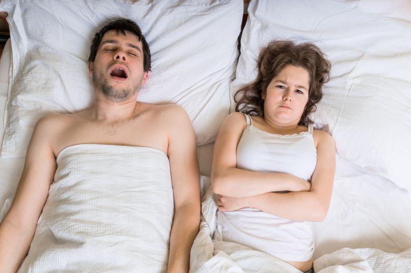 躺在床上打鼾的丈夫和生气的妻子